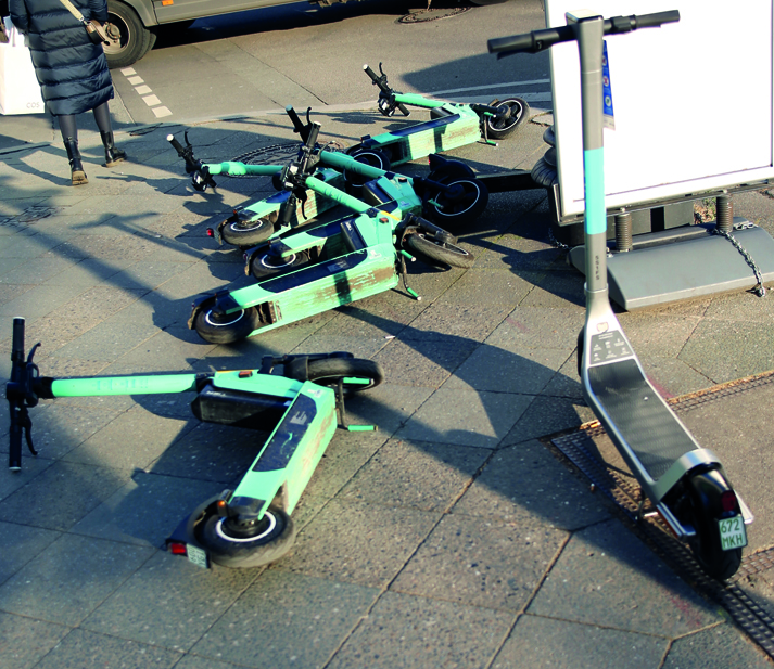 Das Bild zeigt herumliegende und -stehende E-Scooter.