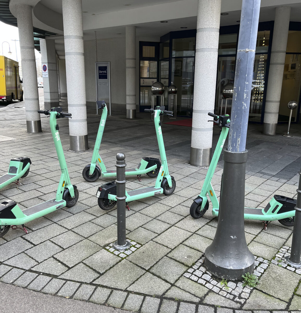 Fünf E-Scooter stehen vor einem Geschäft.